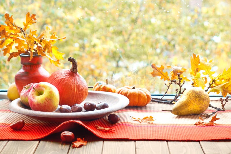 Autumn still life with pumpkins, fruits, chestnuts and dry leave