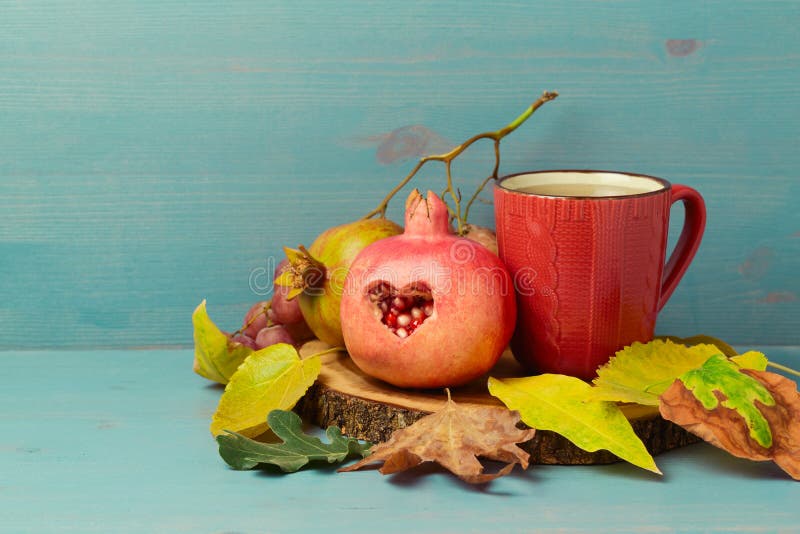 Autumn still life with red tea cup, pomegranate and leaves royalty free stock photo Autumn still life with red tea cup, pomegranate and leaves royalty free stock photo