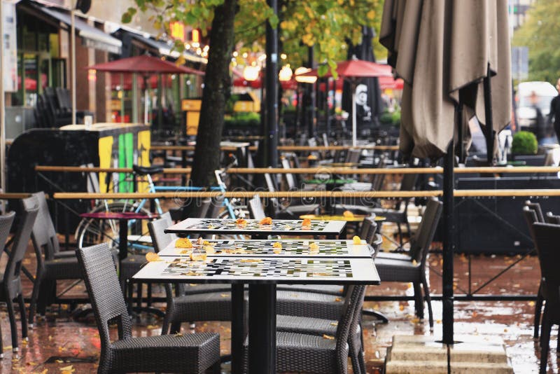 Autumn street cafe with fallen leaves on tables royalty free stock photo Autumn street cafe with fallen leaves on tables royalty free stock photo