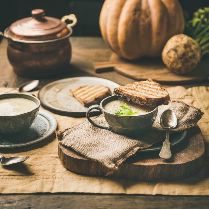 Celery cream soup, toast, fresh pumpkin at background, square crop