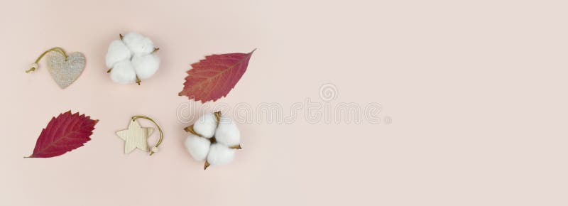 Autumn or winter minimalist composition. Mock up flatlay with fallen leaves, cotton flowers and decoration on pastel background.