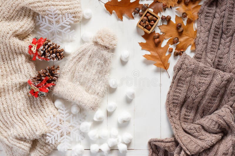 Autumn and winter stylish woman`s outfit. Sweater, hat, shoes and small autumn related items, top view.