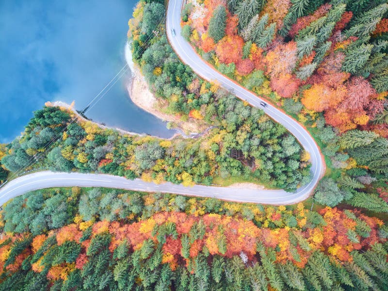 Autumnal landscape view of a mountain road and a lake