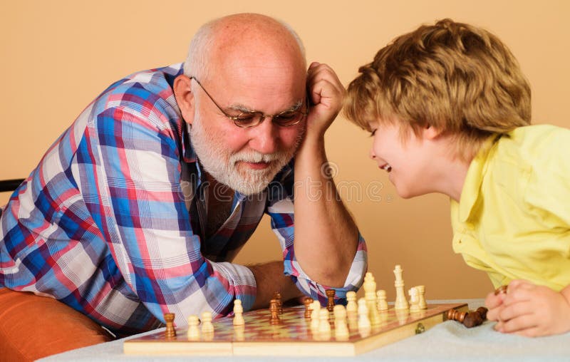 Competição de xadrez infantil e de tabuleiro, garotinho jogando xadrez com  o vovô.
