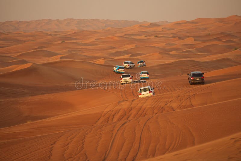 Av-väg affärsföretag med SUV som kör i arabisk öken på solnedgången Offroad medel som slår till och med sanddyn i den Dubai öknen arkivbild Av-väg affärsföretag med SUV som kör i arabisk öken på solnedgången Offroad medel som slår till och med sanddyn i den Dubai öknen arkivbild