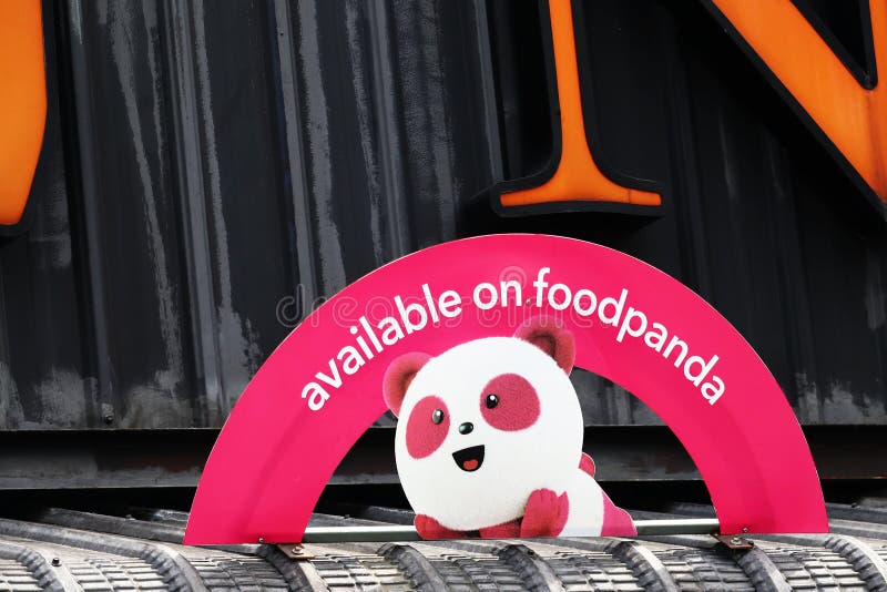 `available on foodpanda` arched signboard on metal awning at a restaurant in Malaysia. `available on foodpanda` arched signboard on metal awning at a restaurant in Malaysia