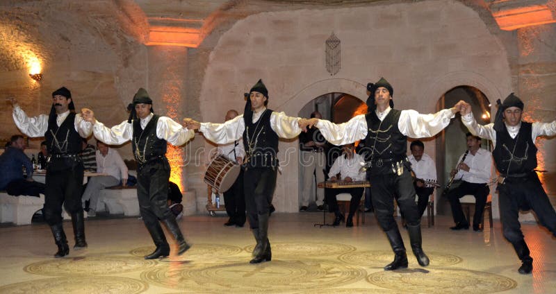 Avanos / Turchia - 25 aprile 2013: Danzatori turchi tradizionali ballano per turisti in un ristorante locale fotografia stock Avanos / Turchia - 25 aprile 2013: Danzatori turchi tradizionali ballano per turisti in un ristorante locale fotografia stock