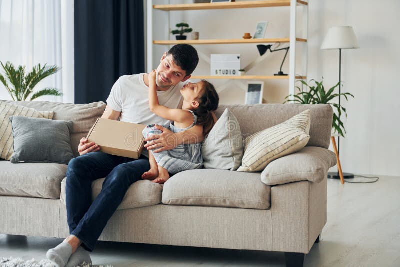 Avec boîte cadeau. le père en civil est à la maison avec sa fille photos libres de droits