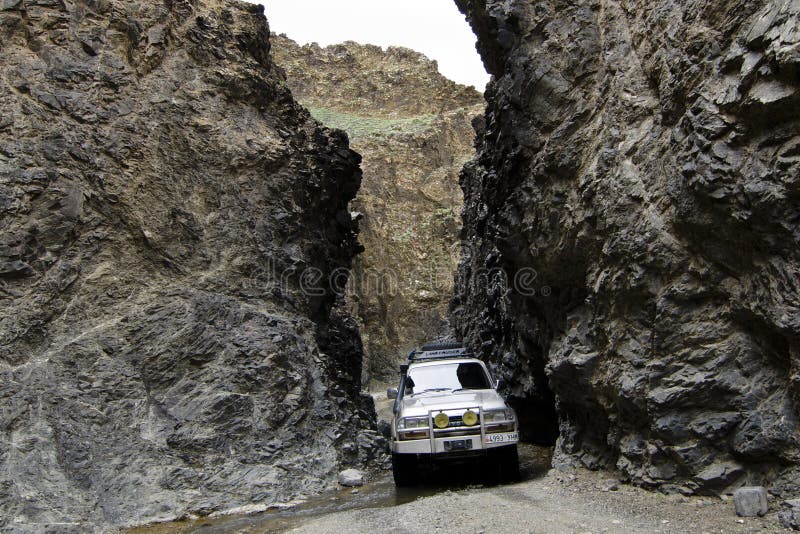 4wd off road suv jeep car adventure driving through a crag in mountain range deep in the Gobi desert. 4wd off road suv jeep car adventure driving through a crag in mountain range deep in the Gobi desert