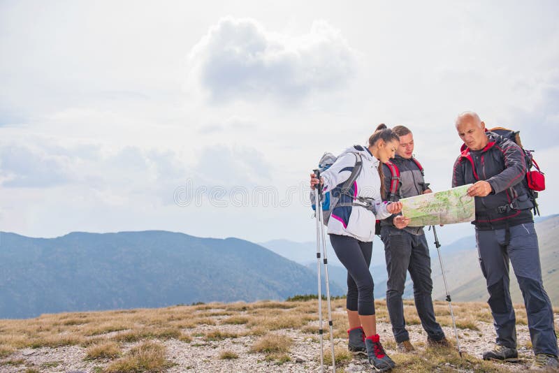 Aventure-se, viaje-se, turismo, caminhada e conceito dos povos - grupo de amigos de sorriso com trouxas e mapa fora foto de stock Aventure-se, viaje-se, turismo, caminhada e conceito dos povos - grupo de amigos de sorriso com trouxas e mapa fora foto de stock