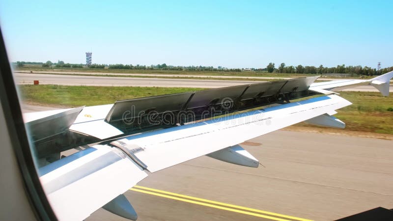 Avion d'atterrissage et conduite sur piste. avion de freinage. vue de la fenêtre sur une aile avec volets de fermeture. spoilers d banque de vidéos