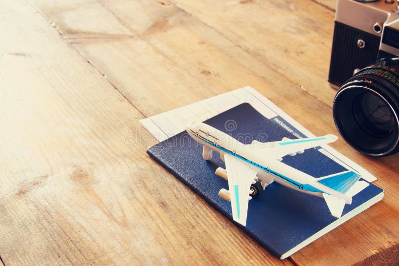 Avion et passeport de jouet au-dessus de table en bois Rétro image de type image stock Avion et passeport de jouet au-dessus de table en bois Rétro image de type image stock