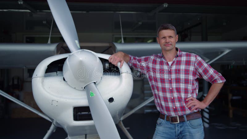 Avion pilot care prezintă un hangar în picioare, înclinat pe corpul aeronavei, închis. stock footage