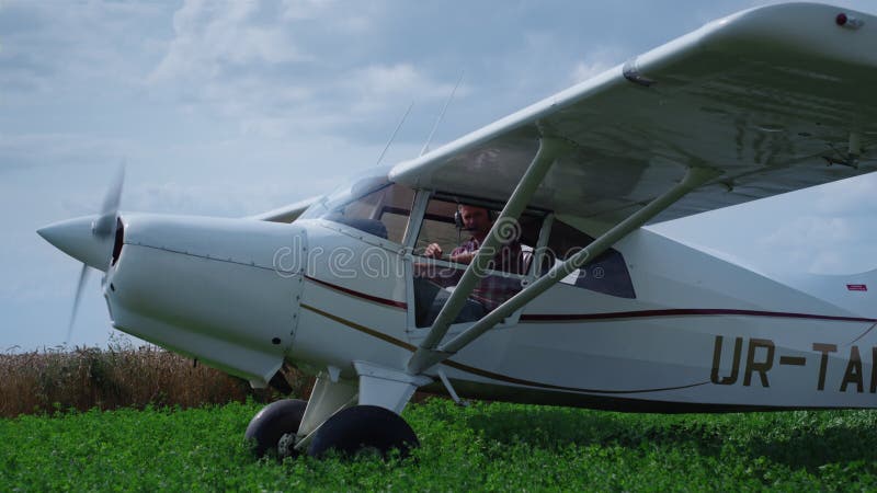 Avion privat pornit motor în picioare pe câmp. avion parcat pe iarbă. stock footage
