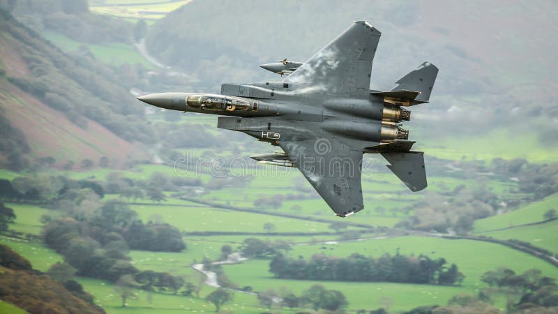 United States Air Force USAF F15 military fighter jet aircraft against Welsh European rural landscape backdrop whilst on a low level training mission. United States Air Force USAF F15 military fighter jet aircraft against Welsh European rural landscape backdrop whilst on a low level training mission.