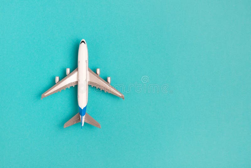 Avião colocado liso no fundo azul Curso do conceito imagem de stock royalty free Avião colocado liso no fundo azul Curso do conceito imagem de stock royalty free