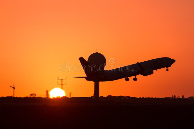 Avión de pasajeros del jet que saca en la salida del sol foto de archivo Avión de pasajeros del jet que saca en la salida del sol foto de archivo