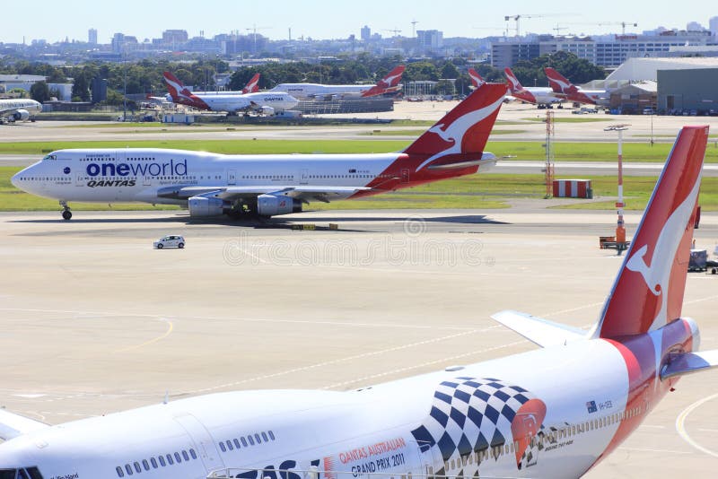 Seven qantas airplanes docking at their terminals with another qantas plane departing - daily routine at Kingsford Smith Airport. Skyline of Sydney in the background. Seven qantas airplanes docking at their terminals with another qantas plane departing - daily routine at Kingsford Smith Airport. Skyline of Sydney in the background.