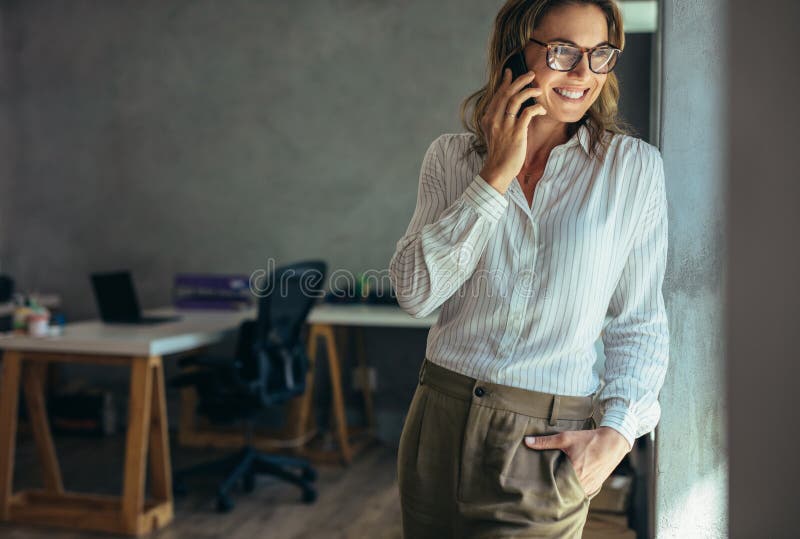 Avkopplad affärskvinna som talar på mobiltelefonen arkivfoto Avkopplad affärskvinna som talar på mobiltelefonen arkivfoto
