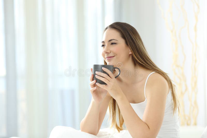 Avkopplad flicka som vaknar ha upp frukosten på sängen arkivbild