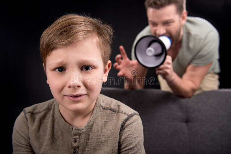 Avla med megafonen som skriker på den förskräckta lilla sonen fotografering för bildbyråer Avla med megafonen som skriker på den förskräckta lilla sonen fotografering för bildbyråer