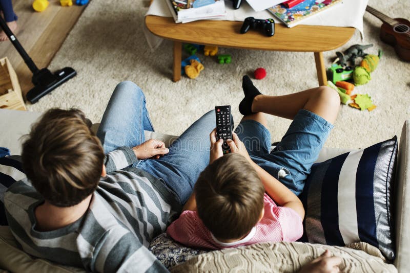 Avlar hållande ögonen på TV för familjen tillsammans och sonen fotografering för bildbyråer Avlar hållande ögonen på TV för familjen tillsammans och sonen fotografering för bildbyråer