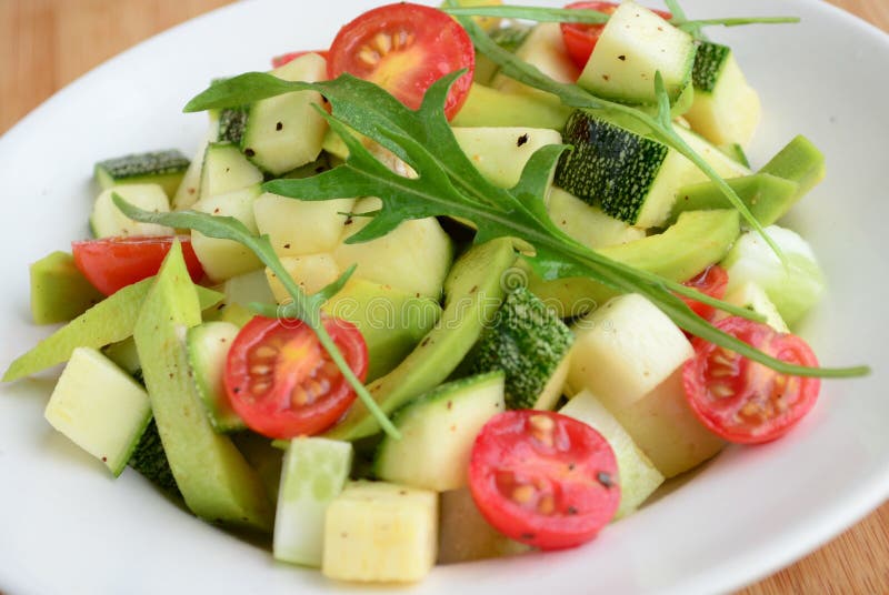 Avocado argula leave salad with cherry tomato vinaigrette dressing