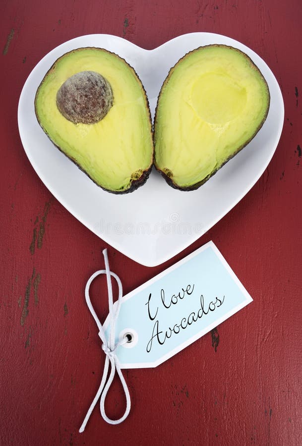 Avocado cut in half on heart shape plate