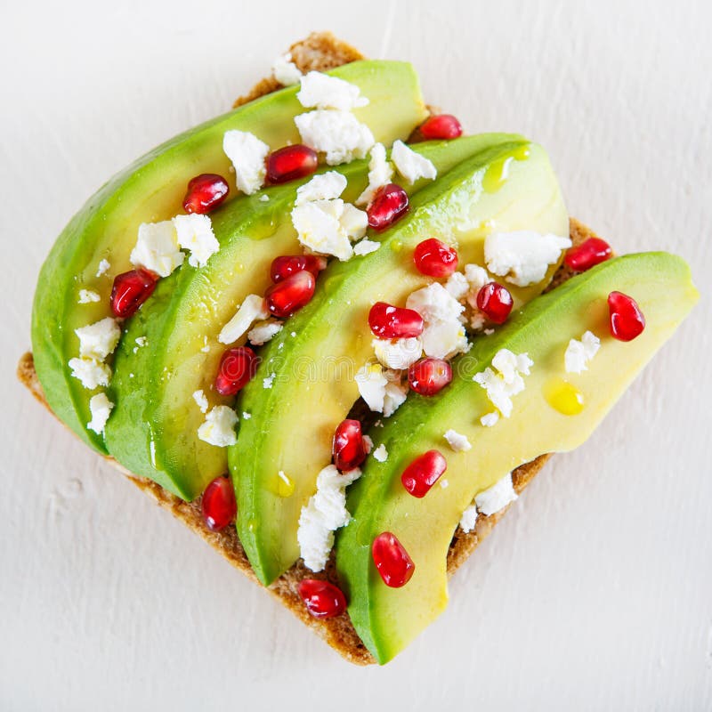 Avocado with Feta, pomegranate on sunflower seeds bread sandwich. Avocado with Feta, pomegranate and olive oil on sunflower seeds bread sandwich. Healthy organic stock photo Avocado with Feta, pomegranate on sunflower seeds bread sandwich. Avocado with Feta, pomegranate and olive oil on sunflower seeds bread sandwich. Healthy organic stock photo