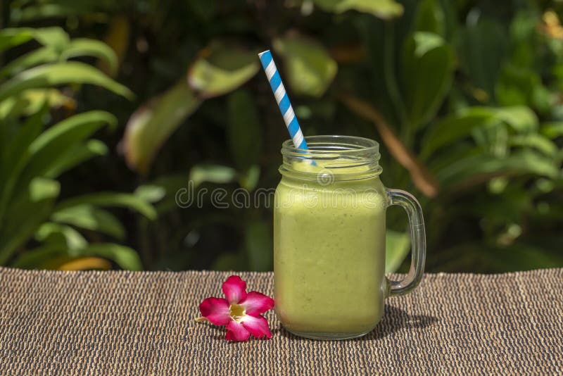 Avocado green shake or smoothie on the table, close up. Breakfast in island Bali, Indonesia