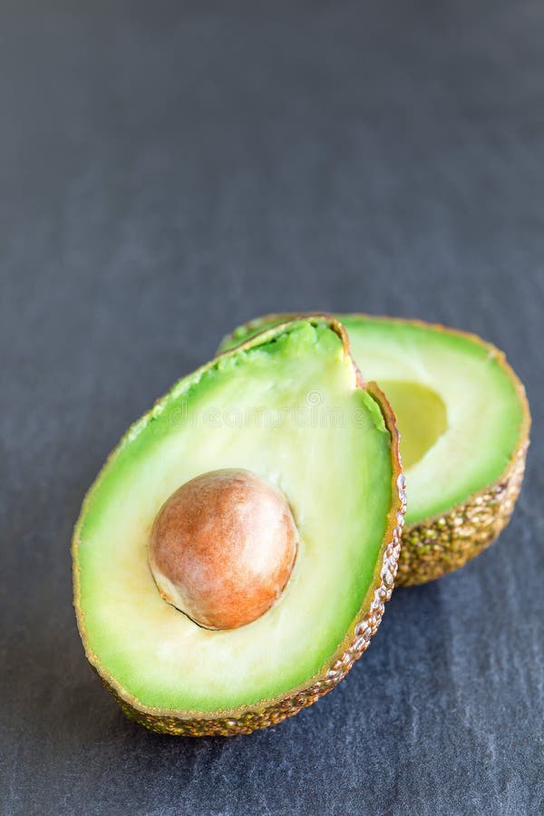 Avocado na ciemnym ?upkowym tle, pionowo fotografia stock Avocado na ciemnym ?upkowym tle, pionowo fotografia stock