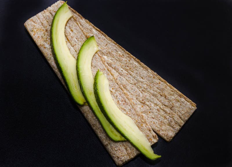 Avocado. Avocado Slices with Glutenfree Bread on Black Background