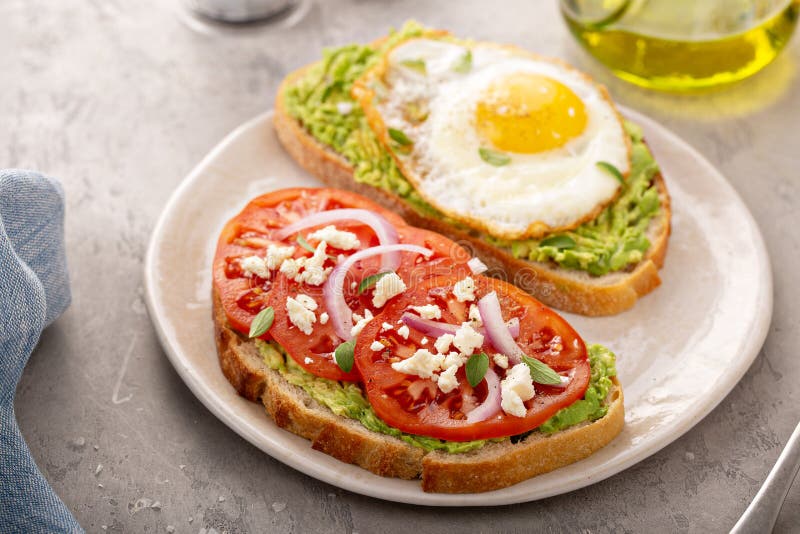 Avocado toasts with fried egg and heirloom tomatoes