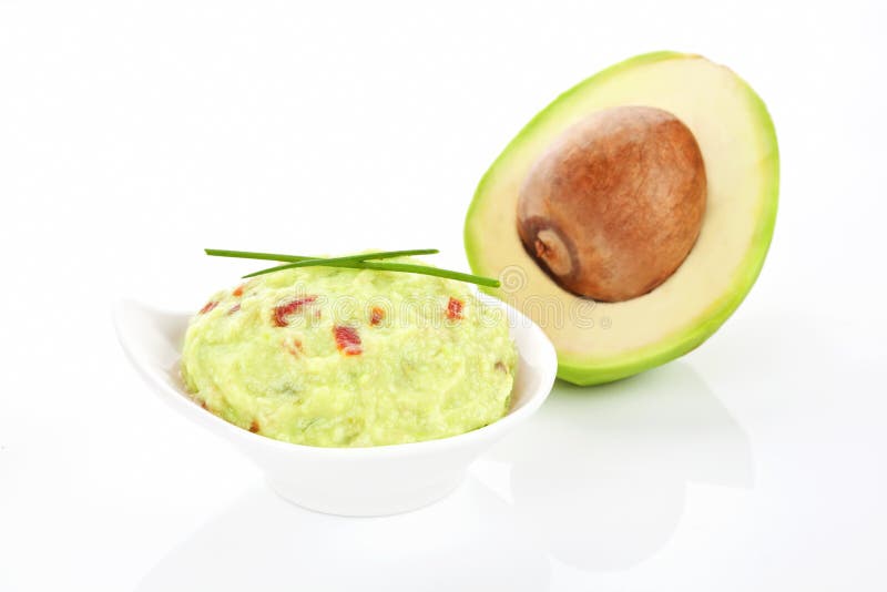 Guacamole dip in bowl and fresh delicious avocado isolated on white. Guacamole dip in bowl and fresh delicious avocado isolated on white.