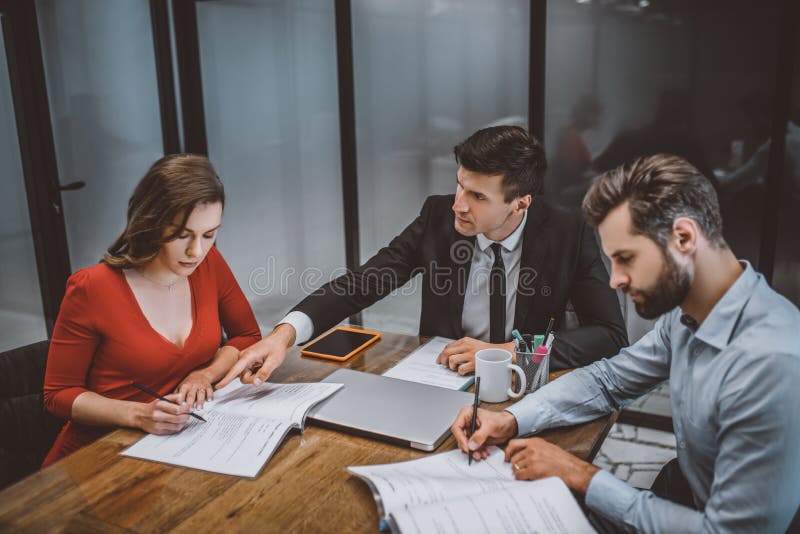 Avocat care ajută un cuplu să completeze actele juridice royalty free stock image