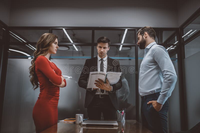 Avocat care citește un document pentru cuplul enervat stock photo