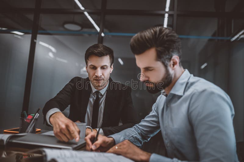 Avocat care se consultă cu un om despre completarea hârtiei stock photography