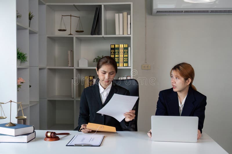 Avocat consultant des documents tout en consultant un client dans un bureau professionnel. photographie stock