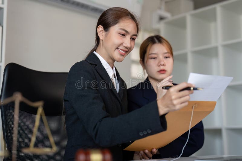 Avocat expliquant les documents juridiques à un client dans un bureau avec un gavel sur le bureau. photos stock