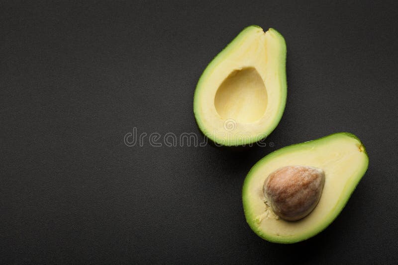 Avocat vert frais d'isolement sur le fond foncé photos stock Avocat vert frais d'isolement sur le fond foncé photos stock