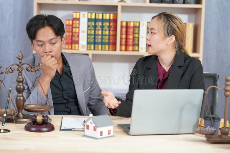 Avocatul care îl consiliază pe client cu privire la acordul ipotecar la domiciliu în timpul negocierilor cu un model de casă și cu royalty free stock photo