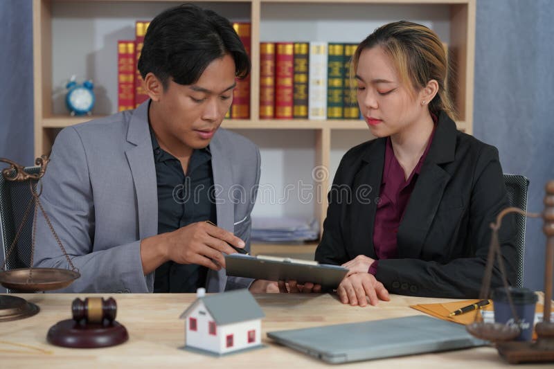 Avocatul care îl consiliază pe client cu privire la acordul ipotecar la domiciliu în timpul negocierilor cu un model de casă și cu royalty free stock photo
