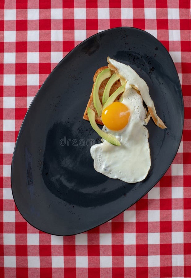 Avokadorostat bröd med det stekte ägget på rostat bröd arkivbilder Avokadorostat bröd med det stekte ägget på rostat bröd arkivbilder