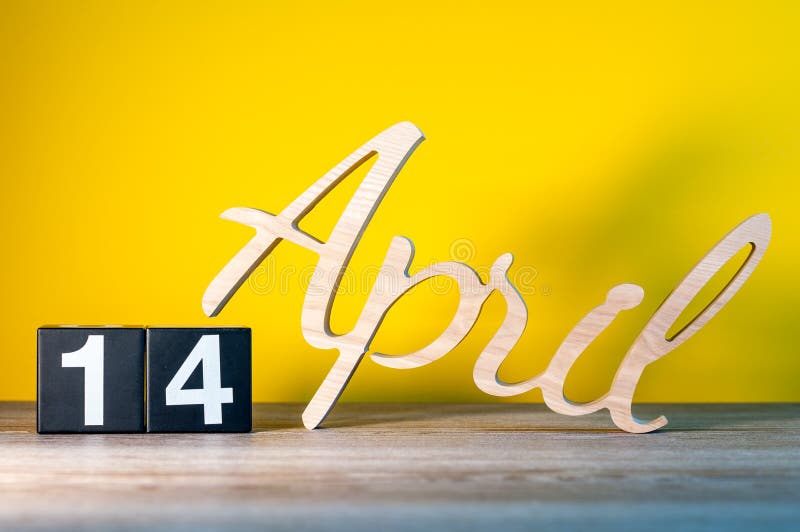 14 avril. Jour 14 du mois, calendrier sur une table en bois et fond vert. Temps de printemps, espace vide pour texte images stock
