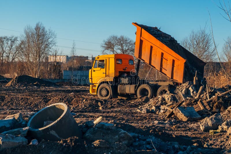 Avskrädedumper som lastar av konstruktionsskräp in i nedgrävning av sopor royaltyfri bild Avskrädedumper som lastar av konstruktionsskräp in i nedgrävning av sopor royaltyfri bild