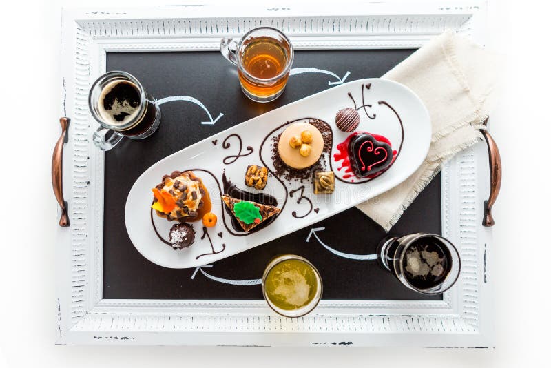 Avsmakning av vin- och pattiechokladbakelser på chokladen royaltyfri foto Avsmakning av vin- och pattiechokladbakelser på chokladen royaltyfri foto