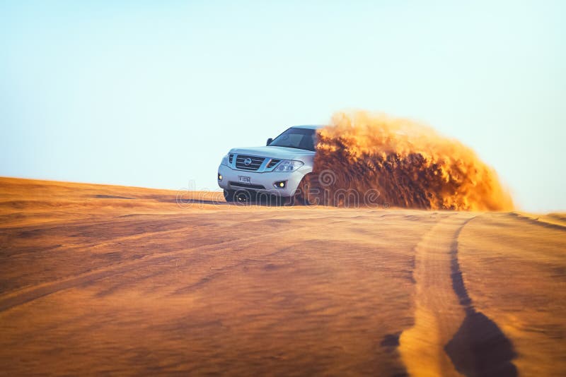 Avventura fuori strada con Nissan Patrol SUV in deserto arabo al tramonto Veicolo fuori strada che colpisce attraverso le dune di fotografia stock libera da diritti Avventura fuori strada con Nissan Patrol SUV in deserto arabo al tramonto Veicolo fuori strada che colpisce attraverso le dune di fotografia stock libera da diritti