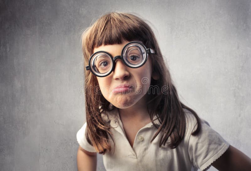 Little girl wearing thick eyeglasses with angry expression. Little girl wearing thick eyeglasses with angry expression