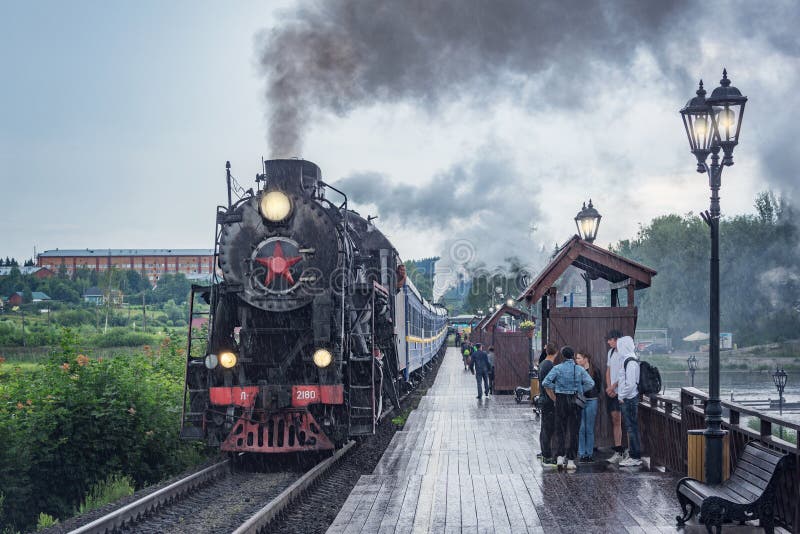 Avvicinamenti del treno a vapore retrorifero alla piattaforma di legno fotografie stock