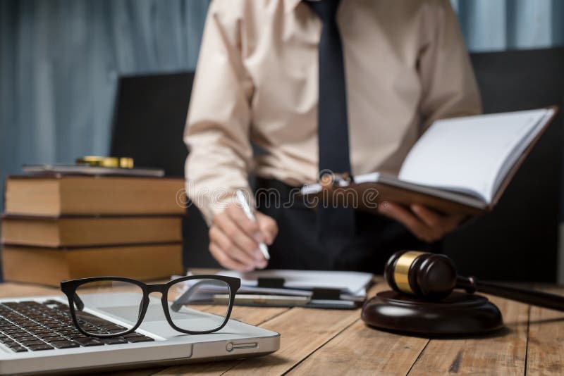 Avvocato di affari che lavora duro nel luogo di lavoro della scrivania con il libro